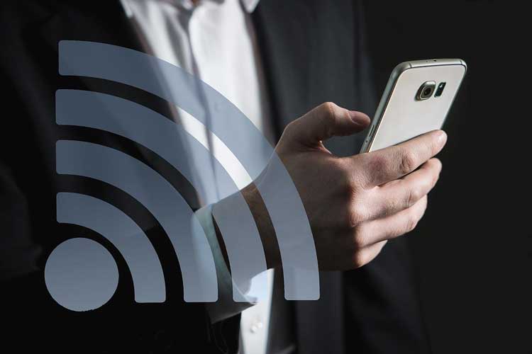 Man holding smart phone with wifi icon